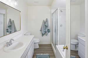 Full bath with vanity, light wood-style flooring, and a shower stall