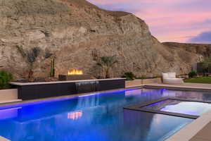 View of pool featuring a patio, a mountain view, and a pool with connected hot tub
