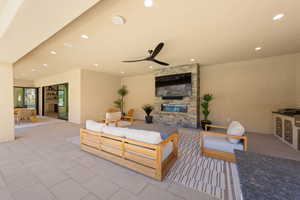 View of patio with ceiling fan, a stone fireplace, and an outdoor kitchen