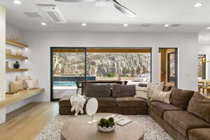 Living area with recessed lighting, light wood-style flooring, cooling unit, and a ceiling fan