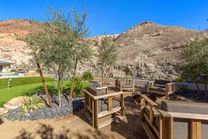 View of patio with a mountain view, an outdoor hangout area, and a putting green