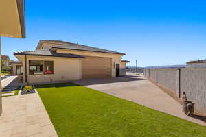 Rear view of house with concrete driveway, stucco siding, and a garage