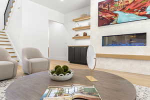 Dining room with light wood-style flooring, a tiled fireplace, and stairway