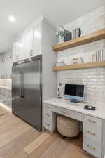 Office space featuring built in study area, light wood-style floors, and recessed lighting