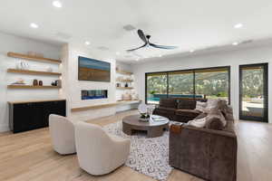 Living area featuring light wood-style floors, a ceiling fan, and recessed lighting