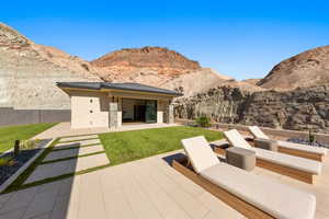 Rear view of property with a patio, a mountain view, a yard, and stucco siding