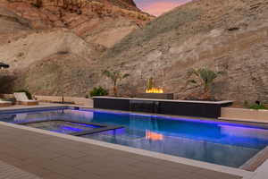 View of pool with a patio and a pool with connected hot tub