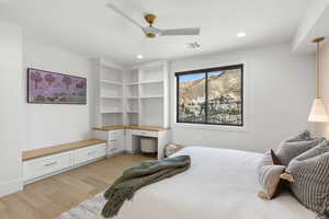 Bedroom with built in desk, light wood-style floors, ceiling fan, and recessed lighting