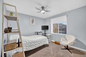Carpeted bedroom with baseboards and ceiling fan