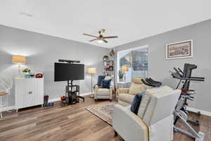 Living area featuring wood finished floors and a ceiling fan