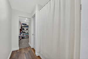 Hallway with dark wood-style floors and baseboards