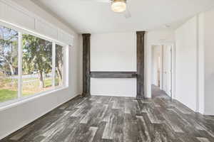 Empty room with dark wood-type flooring and a ceiling fan