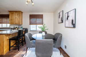 Dining area featuring dark wood-type flooring, plenty of natural light, and a textured ceiling