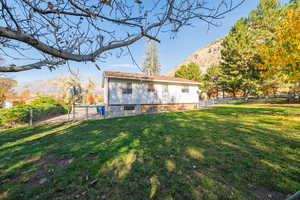 Rear view of property with a mountain view, a fenced backyard, and a gate