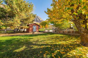 Fenced backyard featuring a storage shed and a mountain view