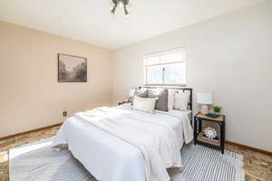 Bedroom #1 featuring stone tile flooring and baseboards