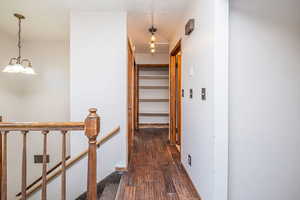 Hall with an upstairs landing, dark wood-style floors, and a textured ceiling