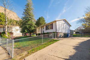 View of front of house featuring a fenced front yard, a gate, and driveway