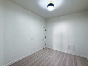 Spare room with light carpet, electric panel, and a textured ceiling