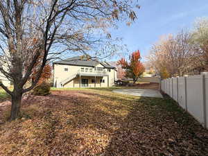 Back of house featuring a patio area, a fenced backyard, stairway, and stucco siding