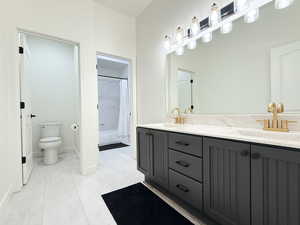 Bathroom with shower / bathtub combination with curtain, double vanity, and light tile patterned flooring