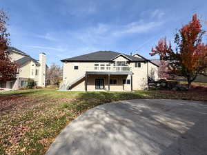 Rear view of property with stairway, a yard, a deck, and stucco siding