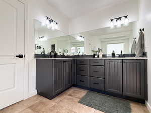 Bathroom with double vanity and light tile patterned flooring