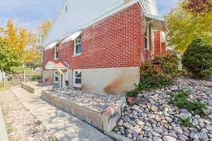 View of home's exterior with brick siding and a gate