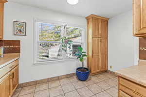 Kitchen featuring backsplash, light countertops, and light tile patterned flooring