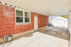 View of patio / terrace featuring an outdoor structure and concrete driveway