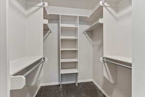 Walk in closet with dark carpet