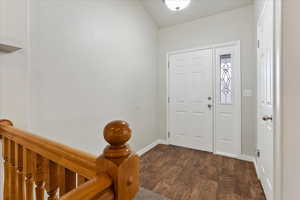 Entrance foyer featuring dark wood-style flooring and baseboards
