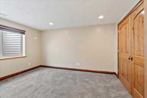 Unfurnished bedroom featuring carpet and recessed lighting