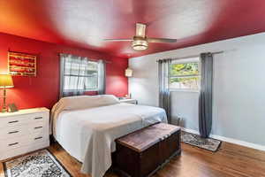 Bedroom with a textured ceiling, laminate floors, and ceiling fan
