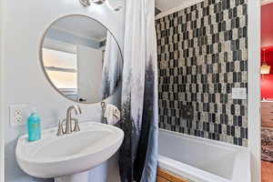 Full bath featuring crown molding and shower / bath combination with curtain
