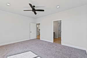 Unfurnished bedroom with light carpet, ceiling fan, recessed lighting, and ensuite bath