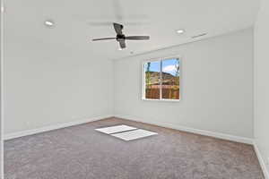Carpeted empty room featuring ceiling fan and recessed lighting