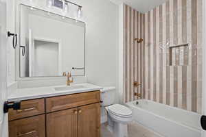 Full bath with  shower combination, vanity, and light tile patterned floors