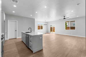Kitchen with an island with sink, recessed lighting, plenty of natural light, a ceiling fan, and light wood-style floors