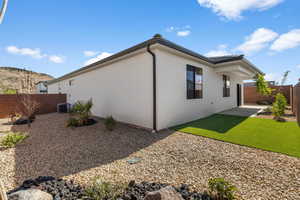 Rear view of property featuring a fenced backyard, a patio, and stucco siding