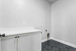 Laundry room featuring washer hookup, dark tile patterned floors, and hookup for an electric dryer