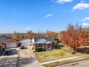View of front of house with a front yard, a residential view, driveway, and brick siding