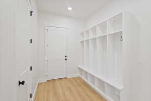 Mudroom featuring light wood-style floors and recessed lighting with cabinets and cubbys.