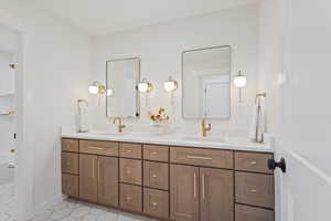 Bathroom featuring double vanity, shower / tub combination, and light tile patterned floors