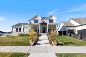 Beautiul view of front of luxury home, featuring covered porch and land scaped front yard.