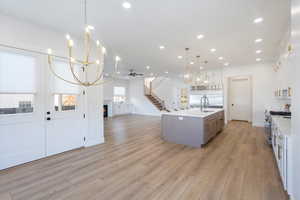 Kitchen featuring a chandelier, white cabinetry, a ceiling fan, open floor plan, and recessed lighting