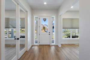Foyer with light wood-style floors, french doors, and recessed lighting