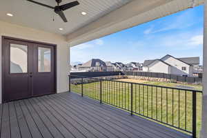 Deck with a residential view, a fenced backyard, and a ceiling fan