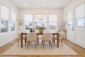 Dining room featuring light wood-style floors, a chandelier, french doors, and recessed lighting