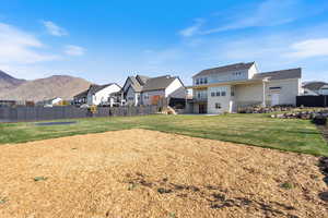 Back of house with a residential view, playset area, and a balcony